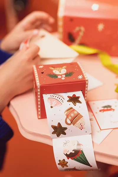 Caixa vermelha de Natal com fita autocolante decorativa a sair