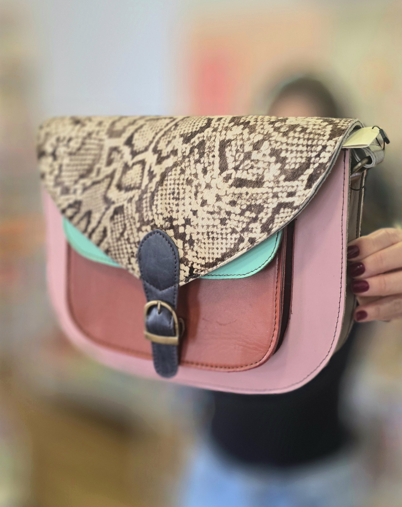 Mala de ombro colorida com padrão de pele de serpente na aba.