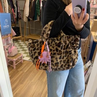 Mala de pelo com padrão de leopardo e pendente roxo