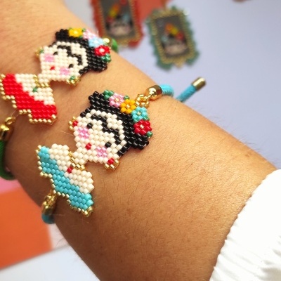 Pulseiras coloridas de missangas com figuras femininas usadas no pulso