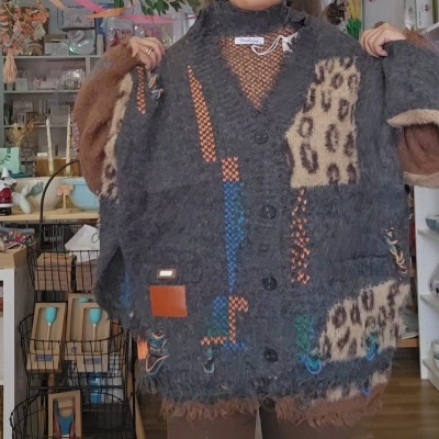 Casaco de malha cinzento com padrão animal e detalhes coloridos