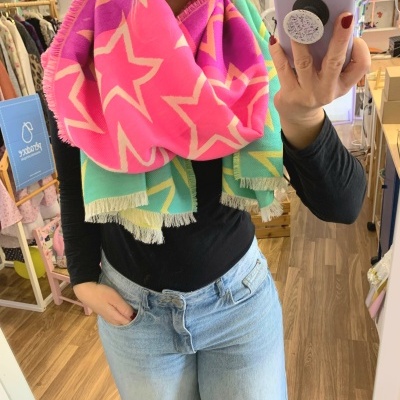 Lenço colorido com estrelas em rosa, verde e amarelo com franjas.