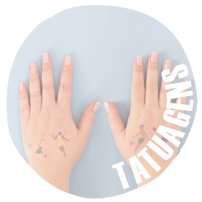 Mãos com tatuagens temporárias de fadas coloridas sobre fundo azul claro