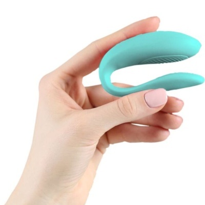 Dispositivo azul claro em silicone segurado por uma mão feminina