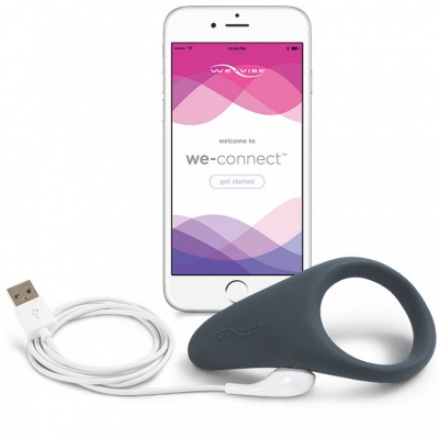 Smartphone branco com ecrã 'welcome to we-connect' e dispositivo cinzento com cabo USB numa superfície branca
