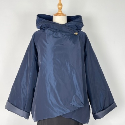 Casaco azul escuro brilhante com gola alta e botão dourado em manequim