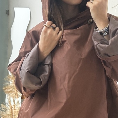 Blusão castanho com capuz e punhos largos usado por mulher