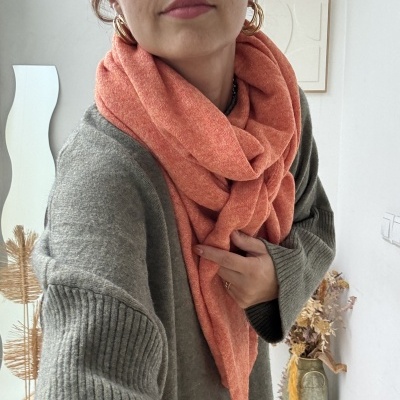 Cachecol laranja grosso e camisola cinza de malha com punhos canelados em interior decorado