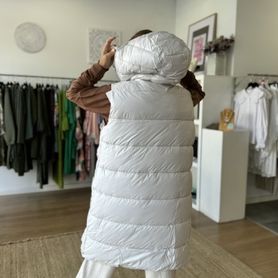 Colete acolchoado branco com capuz grande usado em loja de roupa