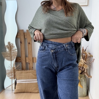 Calças de ganga azuis e camisola verde de malha com brilho