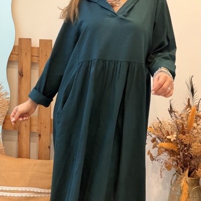 Mulher com vestido comprido verde escuro e botas castanhas