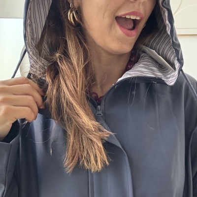 Mulher vestindo casaco impermeável azul escuro com capuz forrado riscado