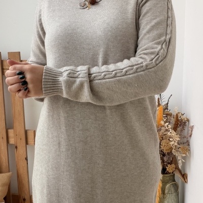 Vestido de malha cinzento claro com padrão trançado nas mangas e acessórios prateados