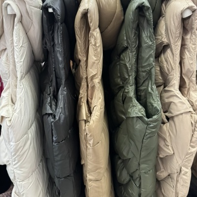 Casacos acolchoados coloridos pendurados lado a lado