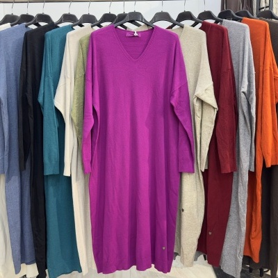 Diversas peças de roupa coloridas penduradas em cabides num suporte