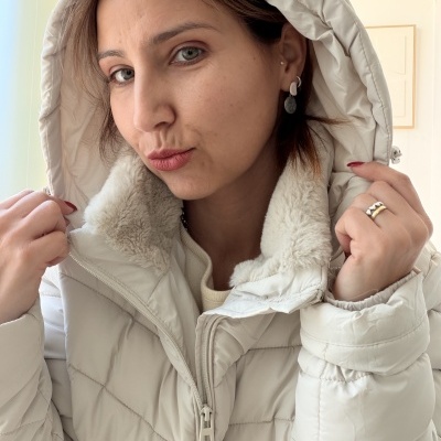 Casaco acolchoado branco com capuz felpudo interior usado por pessoa