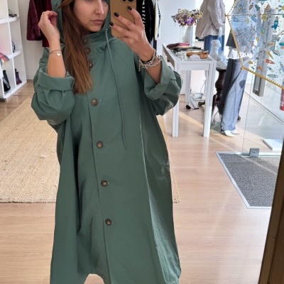 Casaco verde com capuz e botões em loja
