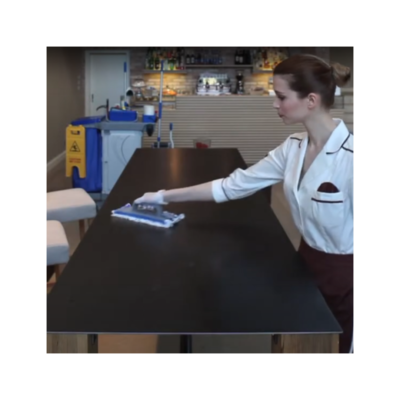 Mulher limpando mesa preta com esfregão azul e branco em interior moderno