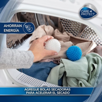 Bolas secadoras branca e azul dentro de máquina de secar com roupas e mão feminina a colocar bola branca