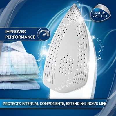 Ferro de engomar branco com base metálica perfurada e roupa passando ao lado