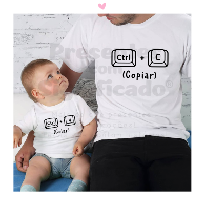 Adulto e bebé com t-shirts brancas, frases de teclado impressas, sentados num sofá azul