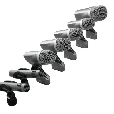 Sete microfones pretos com grelha metálica em suportes ajustáveis