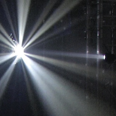 Forte luz branca de holofote com raios num ambiente escuro