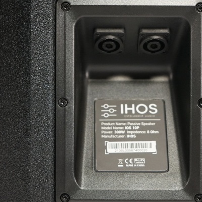 Coluna acústica preta IHOS com etiqueta técnica no verso