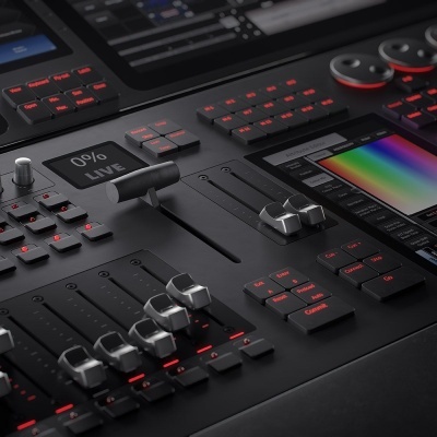 Consola de misturador de áudio preta com botões iluminados a vermelho e ecrã tátil colorido