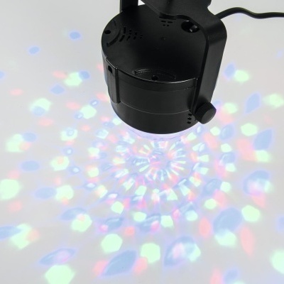 Projetor de luz preto projetando padrão colorido numa superfície clara