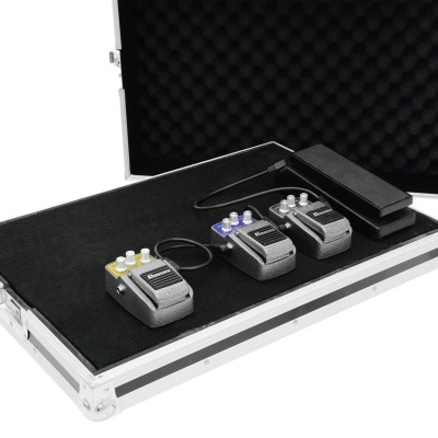 Três pedais de guitarra e um pedal wah dentro de uma mala rígida prateada com interior pret
