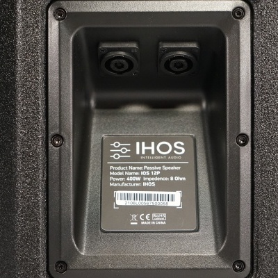 Placa traseira preta de coluna de som com entradas e etiqueta com informações técnicas