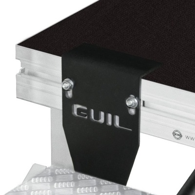 Fixação metálica preta com logo GUIL numa estrutura de palco com superfície preta e base texturizada