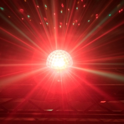 Luz de discoteca vermelha com padrão de pontos circulares num ambiente escuro