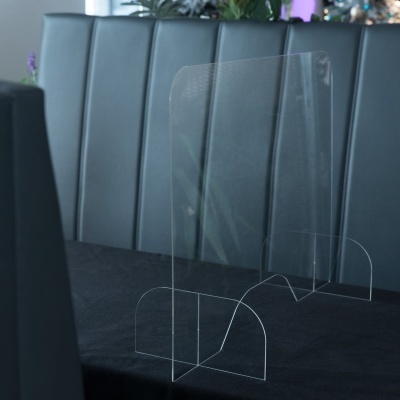 Proteção acrílica transparente numa mesa preta com cadeiras de couro preto