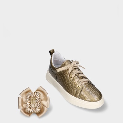 Sapatilha dourada com textura tipo pele de crocodilo e acessório de fita com pérolas