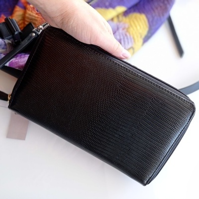 Mala preta pequena texturizada em pele sendo segurada