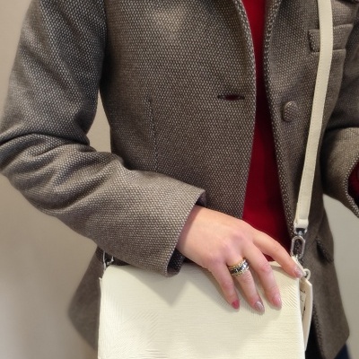 Mala de ombro branca Desigual com padrão texturizado, casaco cinza castanho e camisa vermelha