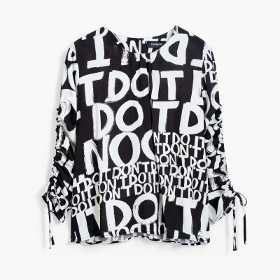 Blusa preta e branca com padrão de texto e mangas drapeadas com laços.