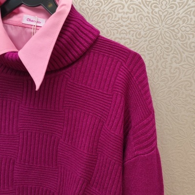 Camisa rosa com camisola de malha roxa texturizada penduradas num cabide