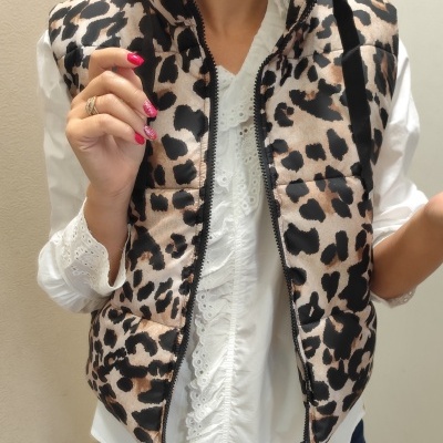 Colete acolchoado com padrão de oncinha usado sobre blusa branca detalhada