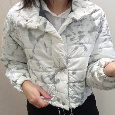 Casaco acolchoado branco e cinza com padrão camuflado e botões de pressão
