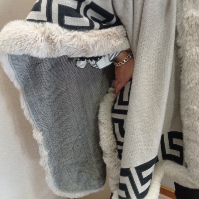 Capa bege com pelo branco e padrão geométrico preto