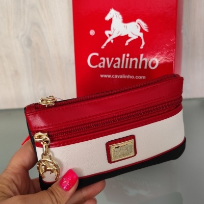 Carteira Cavalinho branca, vermelha e preta com pendente dourado, caixa vermelha ao fundo