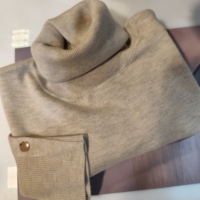 Camisola de gola alta bege claro em malha com botão dourado na manga