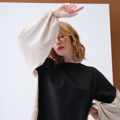 Blusa preta com mangas largas bege em modelo feminino