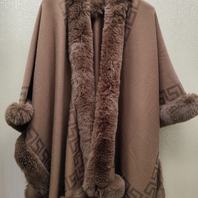 Capa castanha com pelo castanho com padrão geométrico pendurada num cabide preto