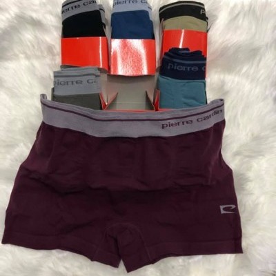 Cuecas boxer Pierre Cardin em várias cores sobre tecido branco peludo.