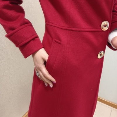 Casaco vermelho feminino com botões dourados e bolsos laterais.