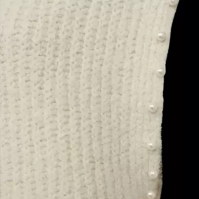 Peça de malha creme canelada com botões perolados na lateral